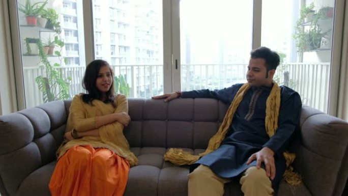 穿着传统印度服装的印度男人和女人坐在一起，经常无聊地闲聊，看起来很被迫