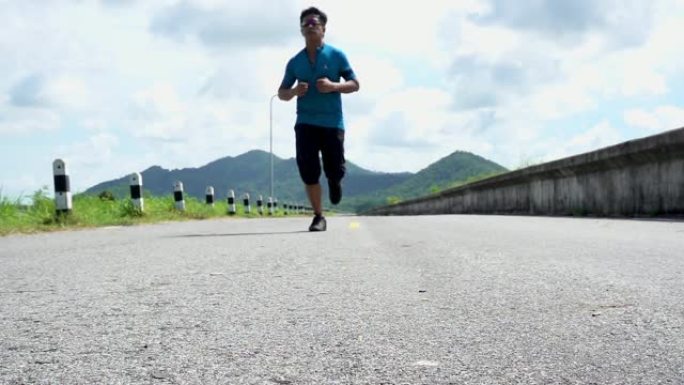 强壮的亚洲男性在外面的路上奔跑。