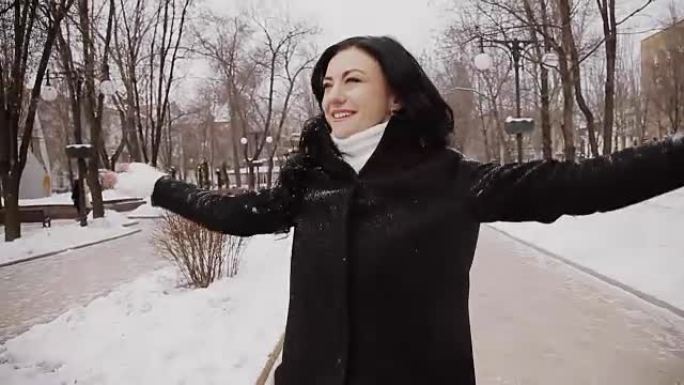 冬天穿着冬装的快乐女孩在公园里扔雪和欢欣鼓舞。