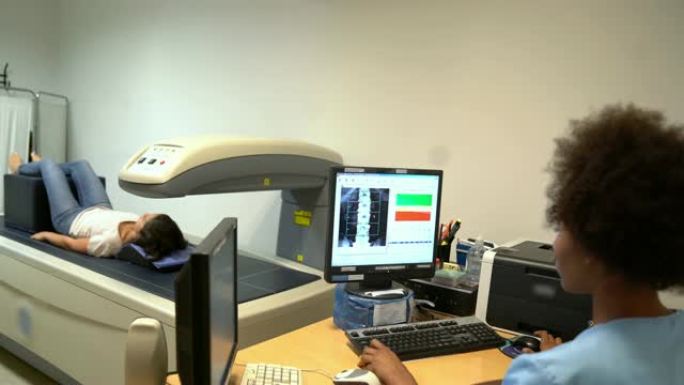 年轻女护士在计算机上分析x射线