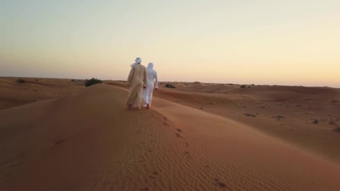 走在沙丘上的阿拉伯人