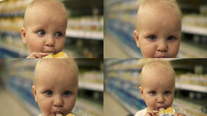 小婴儿从坐在超市手推车上的塑料瓶中喝果汁。口渴的小孩和家人一起购物