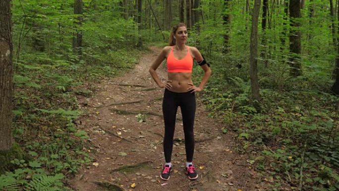 运动女人在森林跑道上慢跑后值得，经常呼吸沉重