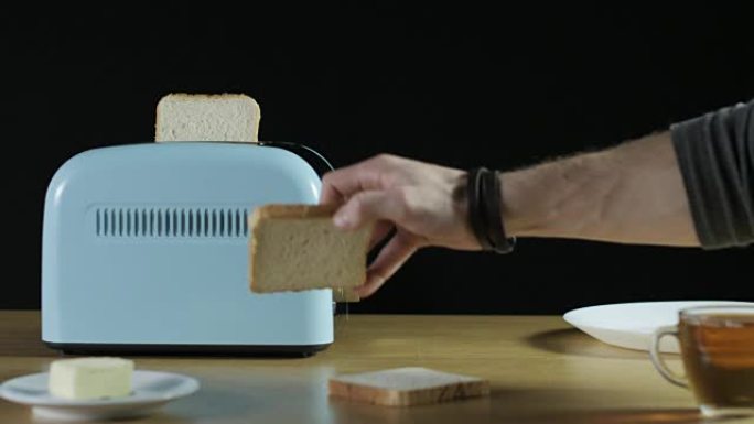男子将两个面包放入电烤面包机中