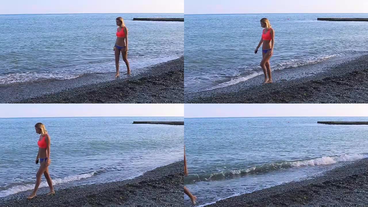 孤独的女孩沿着海滩散步，看着地平线。