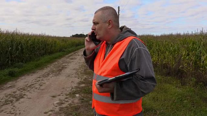 农民在玉米田里用智能手机聊天