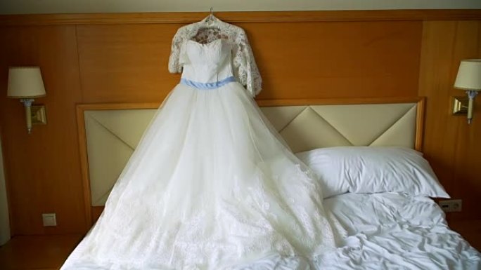 优雅的婚纱躺在酒店房间的床上