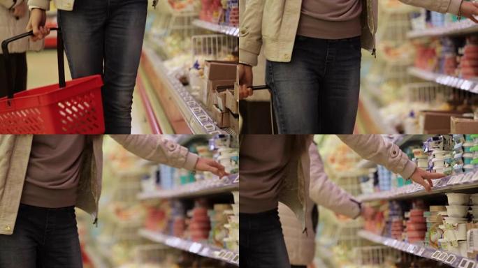 带着购物篮的女人在超市选择冷藏食品。