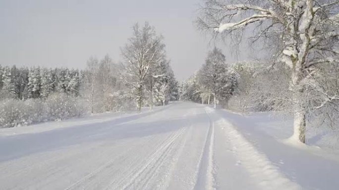 一辆白色汽车在白雪皑皑的街道上疾速行驶