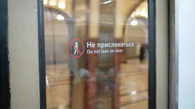 从莫斯科的Mayakovskaya地铁站发货。从带有 “请勿靠在门上” 标签的地铁玻璃门上观看