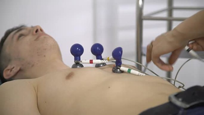 男性患者躺在病房附近进行心电图检查