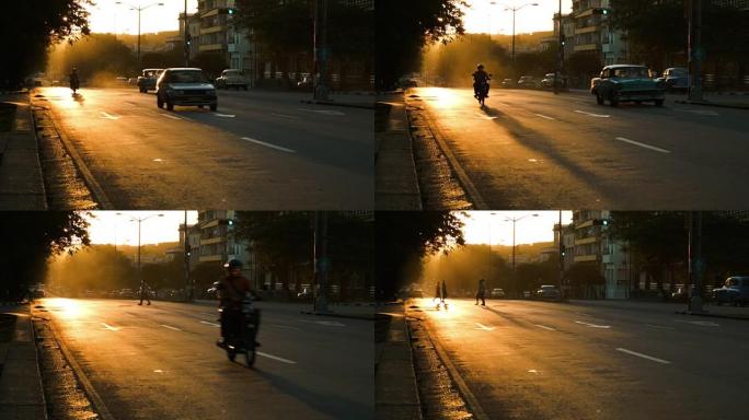 哈瓦那日落期间的摩托车和行人