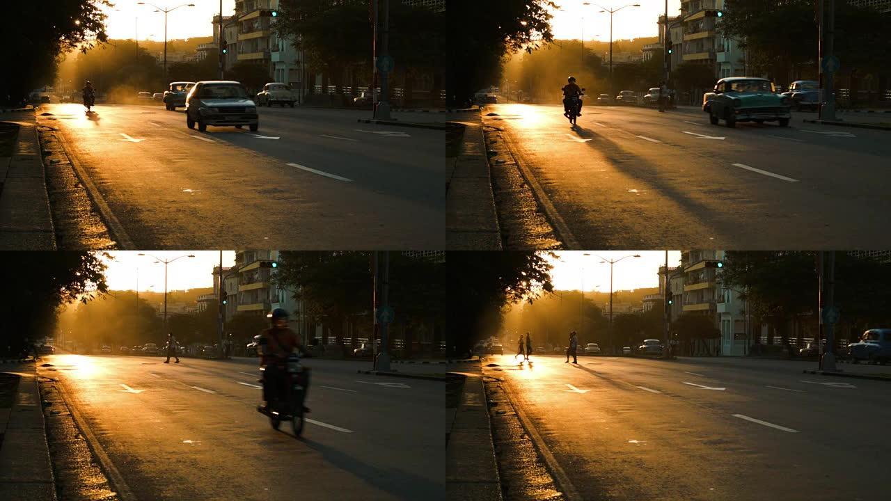 哈瓦那日落期间的摩托车和行人