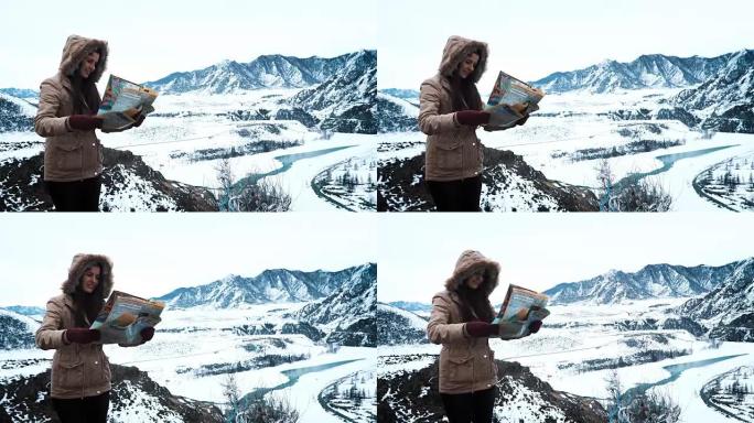 年轻旅游妇女在冬季山区旅游时探索山地地图，度假概念
