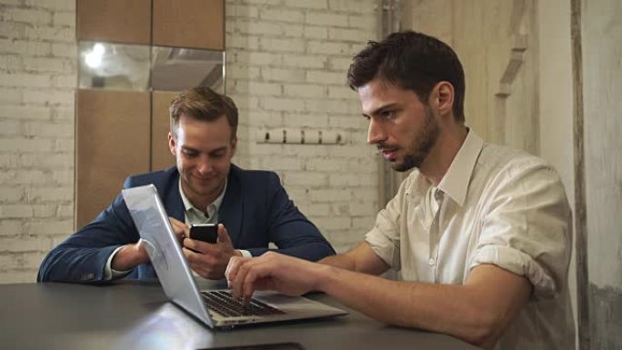 两个商人在现代小工具上阅读新闻并在社交网络服务中聊天