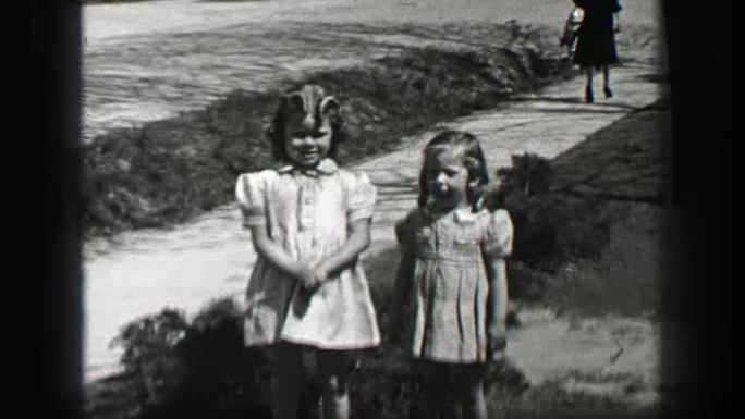 1939: 年轻女孩在礼服与波浪卷曲长刘海发型。