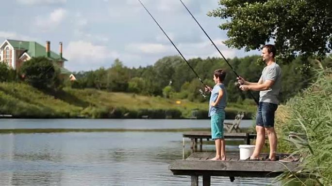 爸爸和十几岁的男孩一起在湖上钓鱼