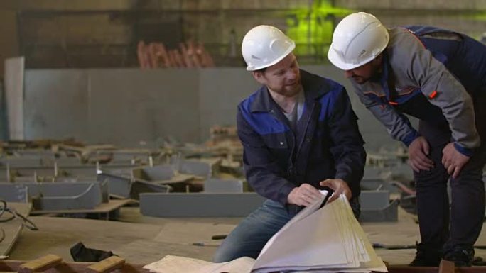工程师查看建筑计划并讨论重工业工厂的建设阶段