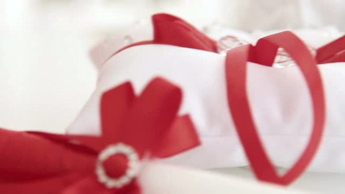 红色结婚枕头，戒指上有蝴蝶结，礼物和
