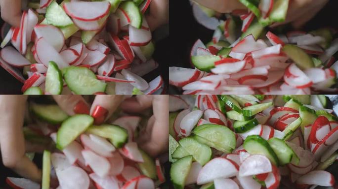女孩的手用红色指甲在沙拉碗中混合萝卜和黄瓜片