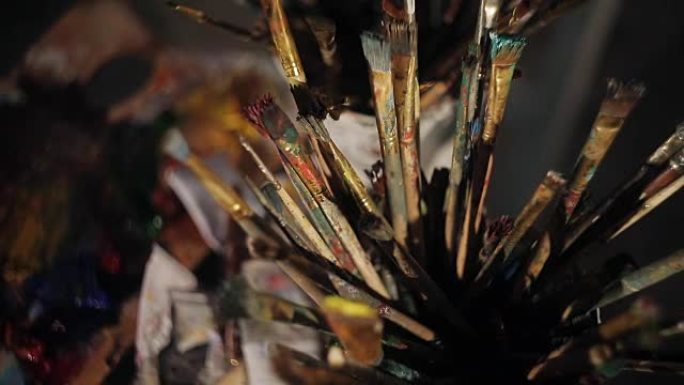 许多画笔，沾满了油画颜料。艺术工作室