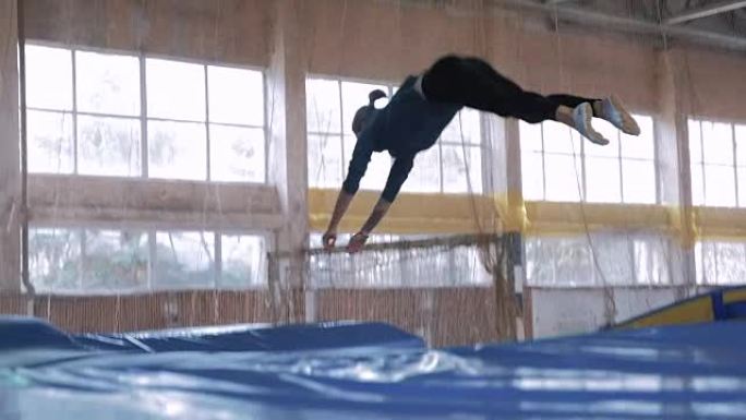 体操运动员在蹦床上跳跃，慢动作