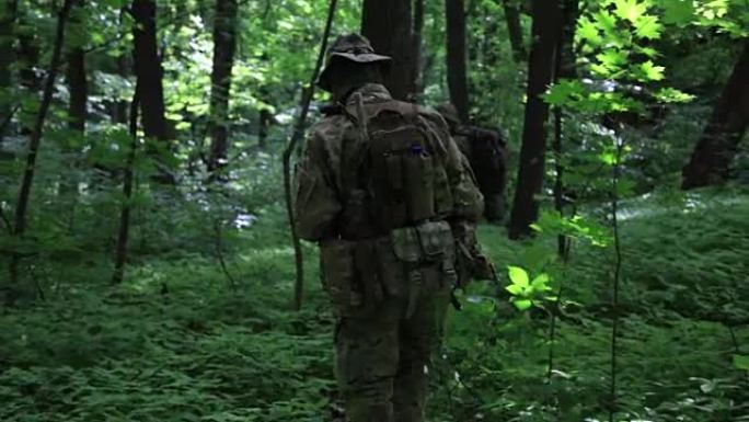游击队员们带着枪在森林的灌木丛中排成一个队形奔跑