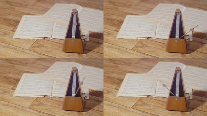 带有银色钟摆的老式节拍器节奏缓慢，背景是一本开放的音乐书