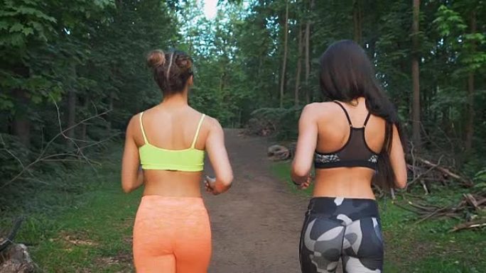 两个健身女孩在树林里跑步。他们践行运动生活方式。为了健康和调剂