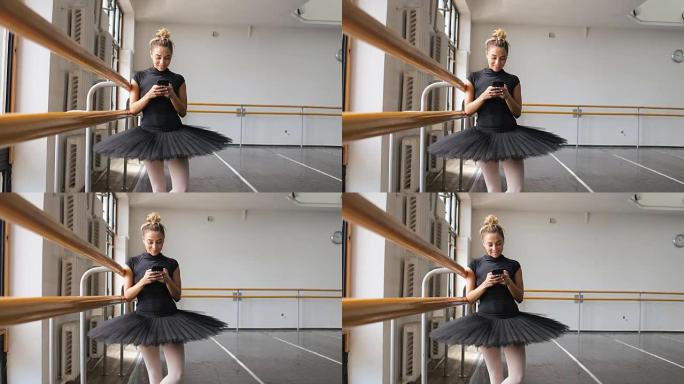 芭蕾舞演员在大型训练馆中使用智能手机