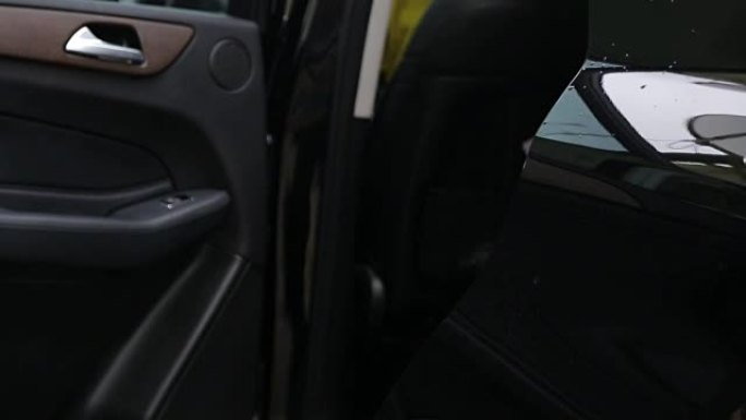 男子在特写镜头中打开车门，在车内设置并关闭车门