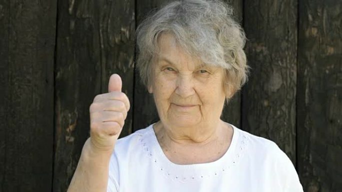 老年妇女在户外竖起大拇指
