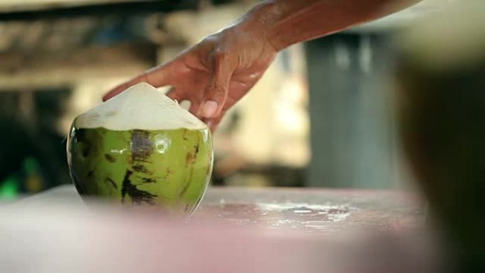 一个人用大刀打开椰子。