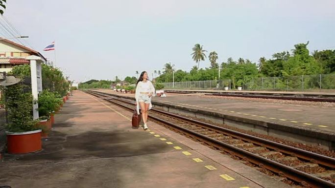 女人带着包在火车站平台上行走