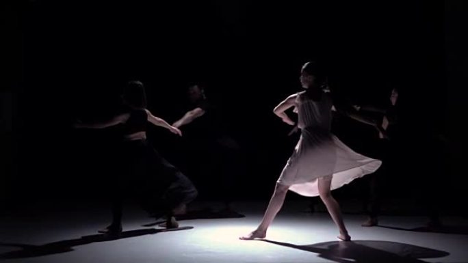 在黑色，阴影，慢动作上继续五位舞者的当代舞蹈