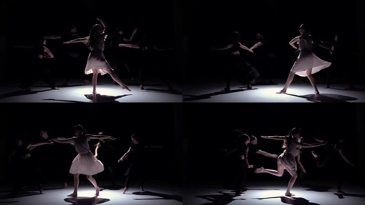 在黑色，阴影，慢动作上继续五位舞者的当代舞蹈