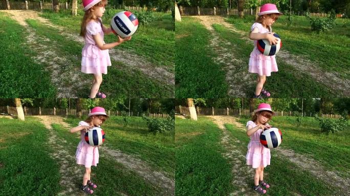 女童在草坪上打球。面对一个快乐地微笑的女孩。