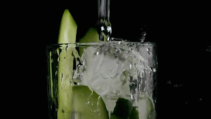将水倒入装有黄瓜和冰的玻璃杯中。慢动作