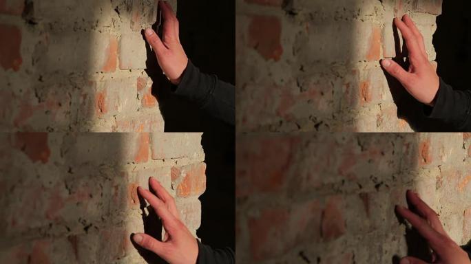 男子手触摸砖砌旧墙