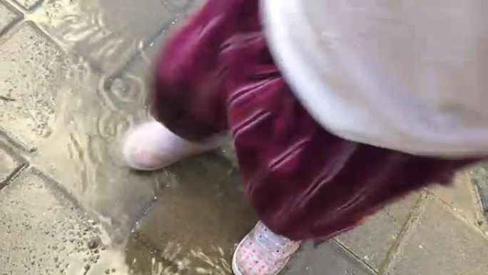 小女孩踩在水坑上