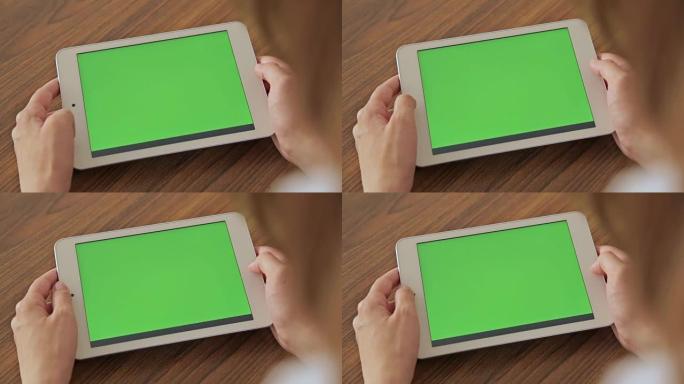 手握绿屏显示的漂亮女人平板电脑