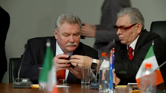 国际会议期间，两名代表用智能手机相互展示