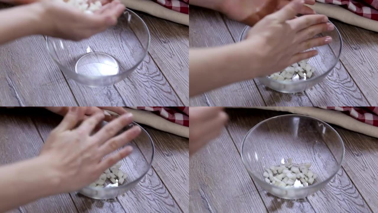 女性的手在碗中摆放洋葱片特写