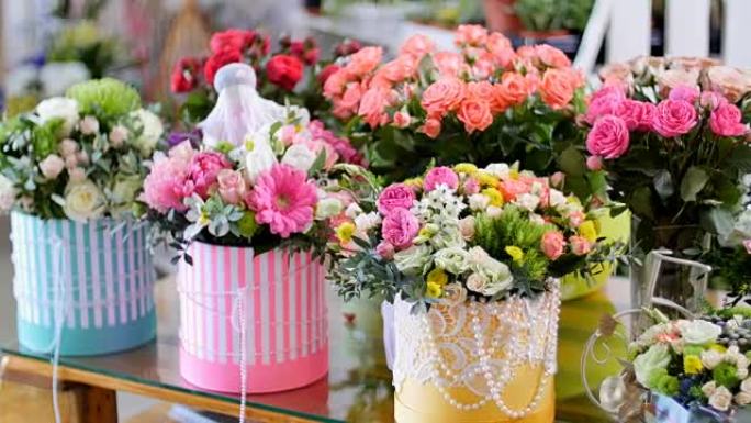 花店，在橱窗上，有很多由介子形玫瑰制成的花束，在五颜六色的盒子里有不同的花朵的花卉时尚组合