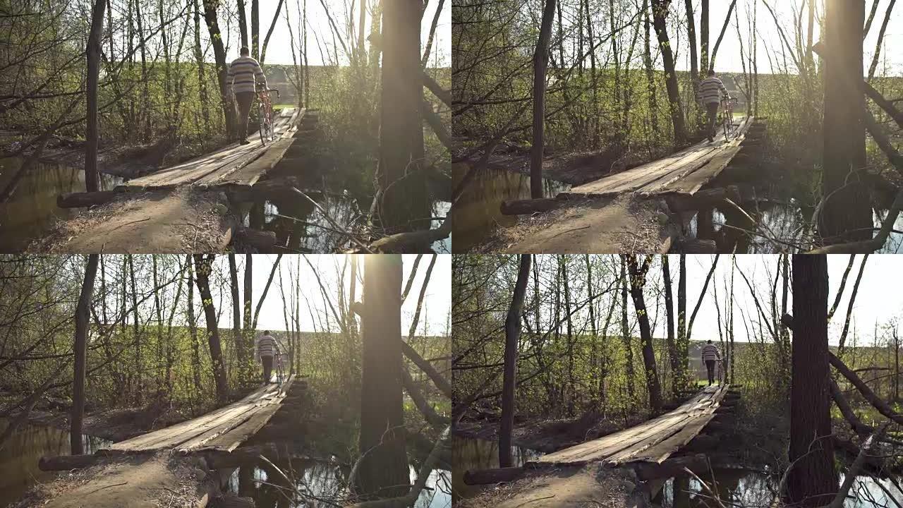 骑自行车的人在一座木桥上过河的公园里散步。慢动作