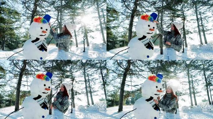 冬天森林里美丽的女孩在很多雪的背景下雕刻雪人，美丽的冬天，阳光明媚的日子