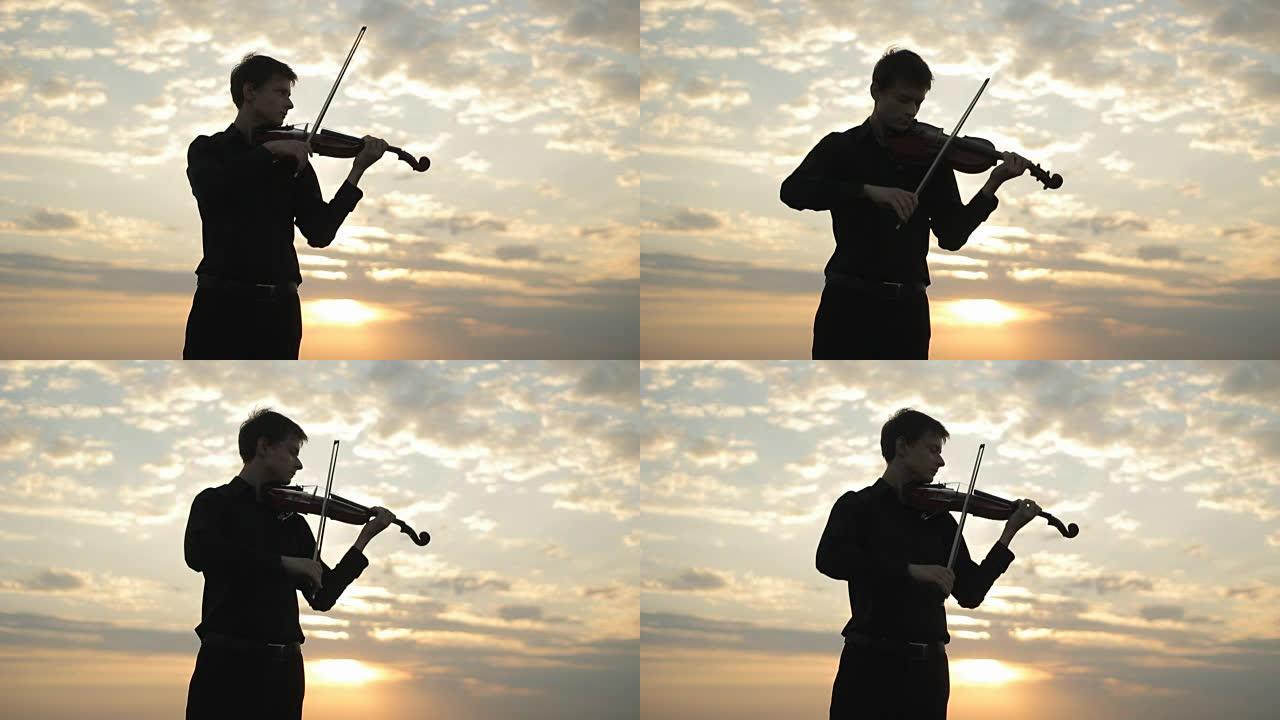 一位穿着黑色衬衫的年轻小提琴手在屋顶上演奏