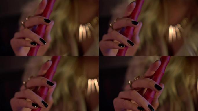 水烟管在一个黑色修指甲的年轻女孩手中。特写