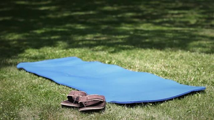 在公园里拍摄的空瑜伽垫和凉鞋或人字拖