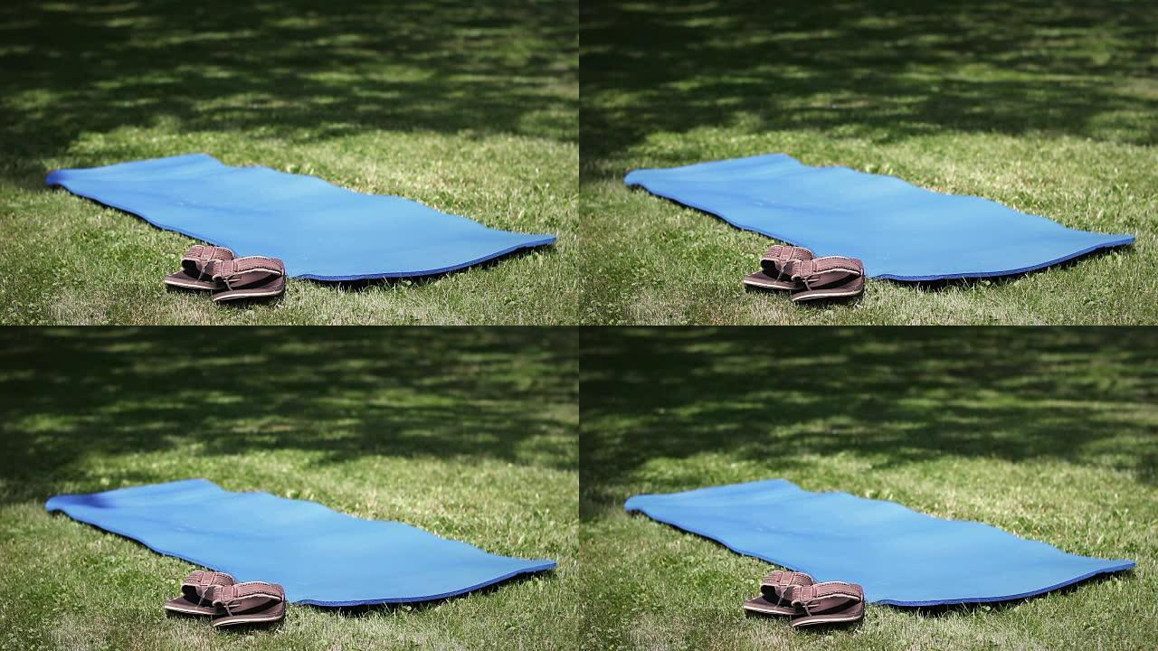 在公园里拍摄的空瑜伽垫和凉鞋或人字拖